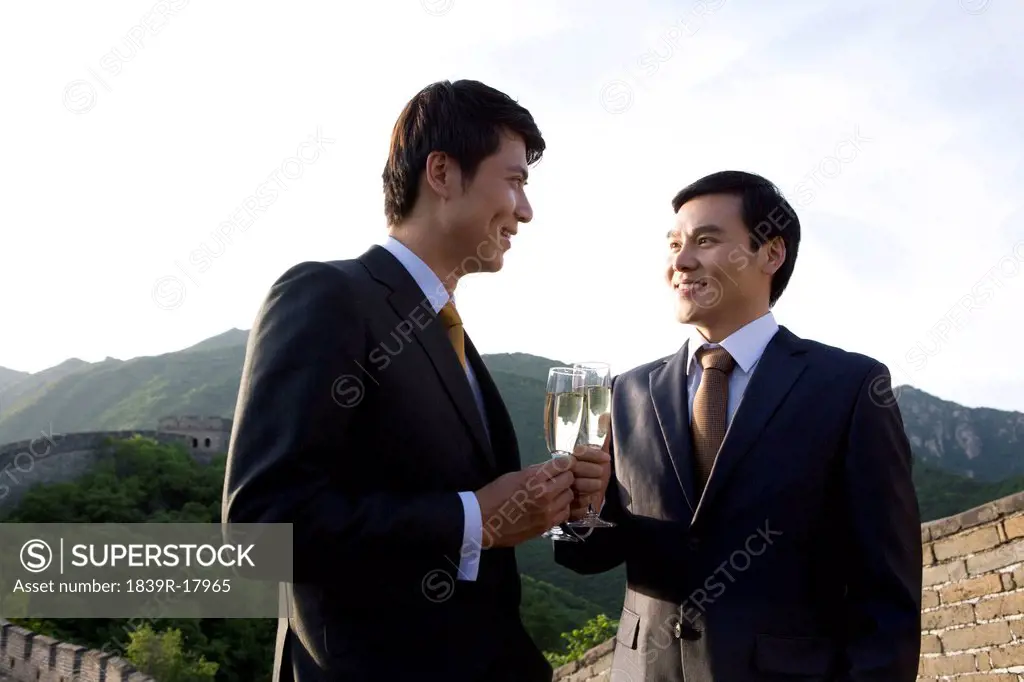Businessmen having champagne on the Great Wall