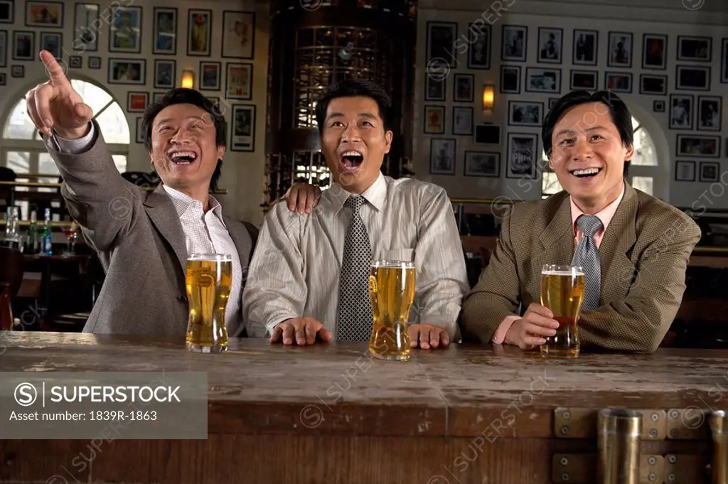 Happy Businessmen Drinking At Bar