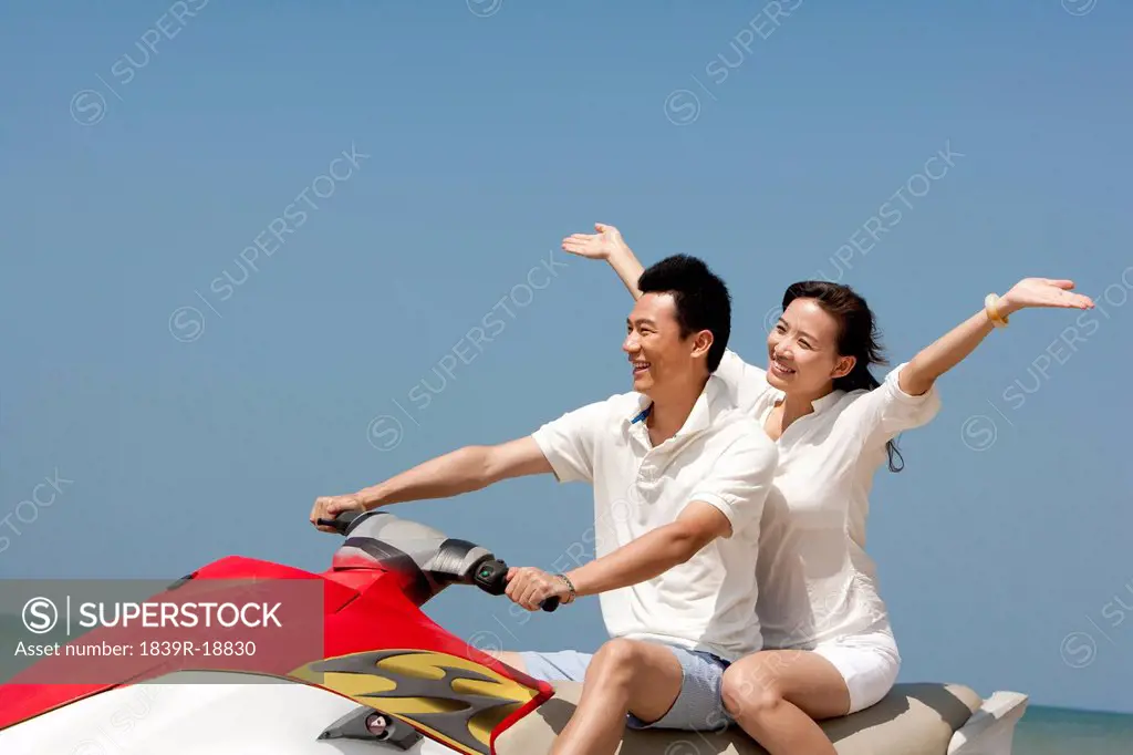 Happy Couple Riding on a Jet Ski