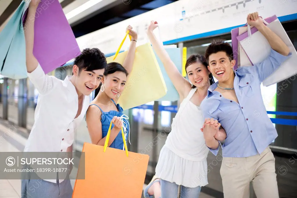 Friends Carrying Shopping Bags at the Subway Station
