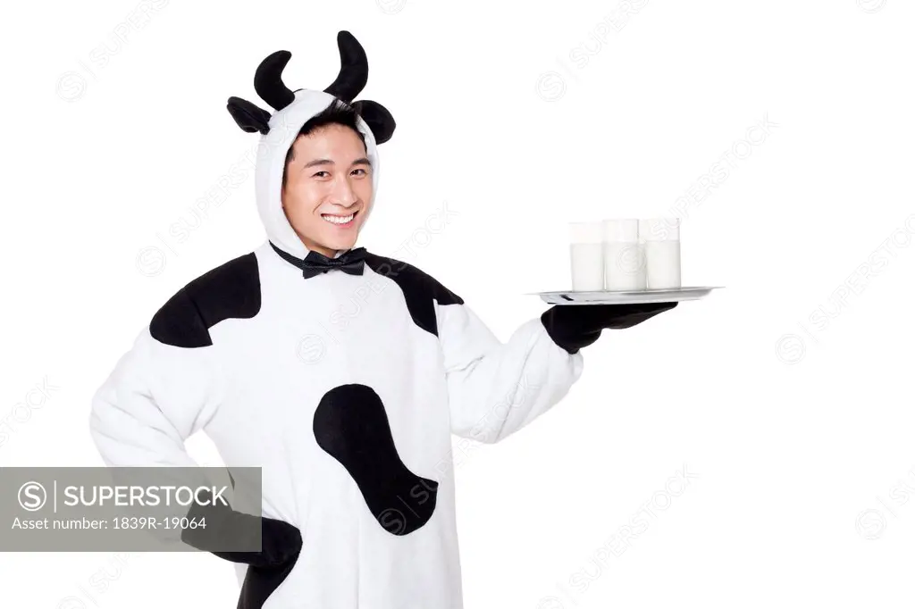 Man in cow costume with a serving tray of milk