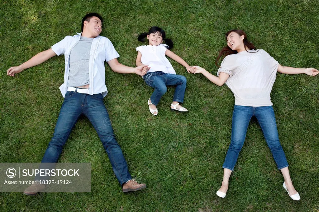 Young Chinese family lying on the grass