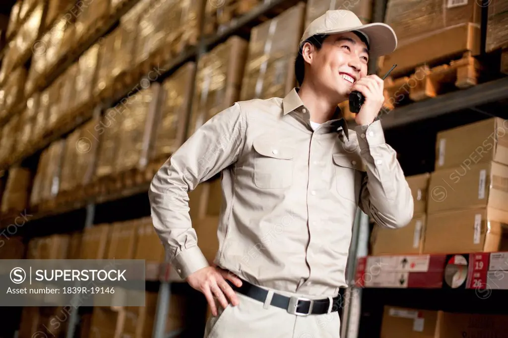 Male Chinese warehouse worker with walkie_talkie
