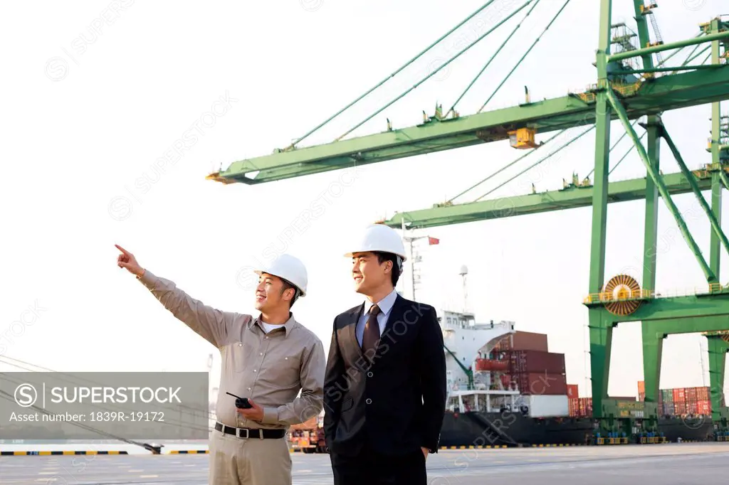 shipping industry worker showing a businessman around the port