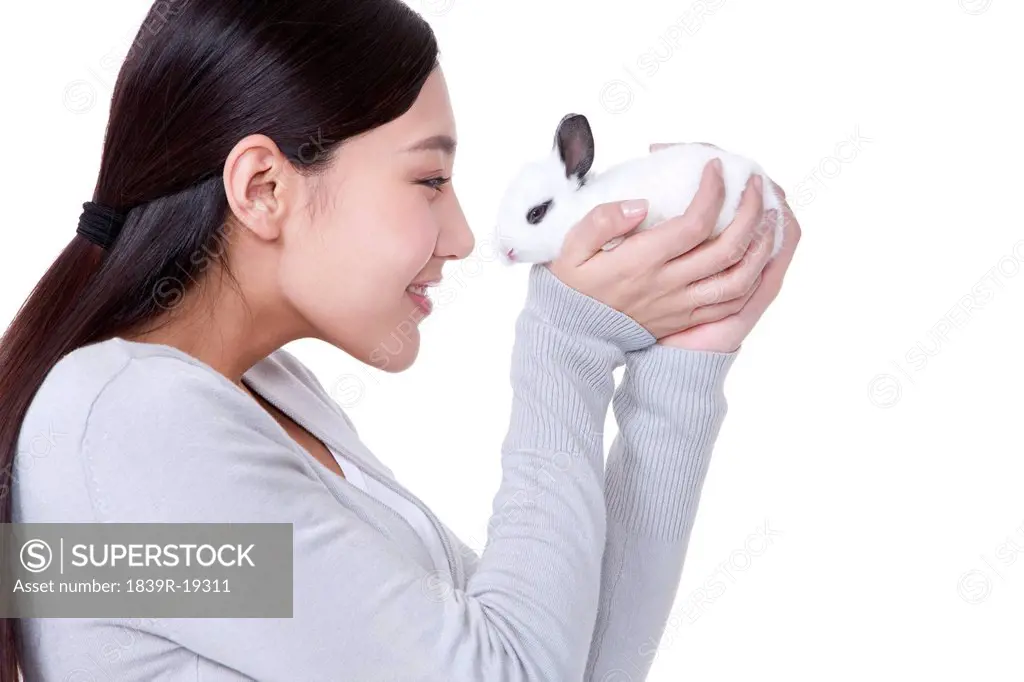 Young woman playing with rabbit