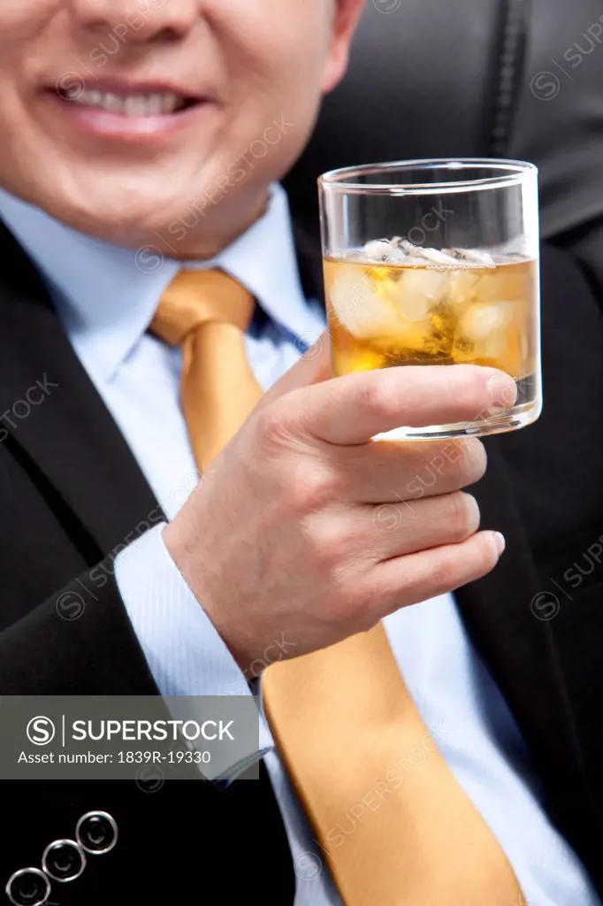 Businessman holding a glass of whiskey