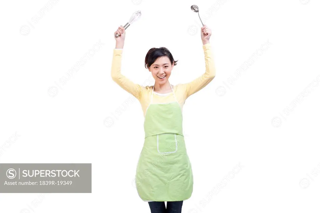 Happy housewife and cooking utensils