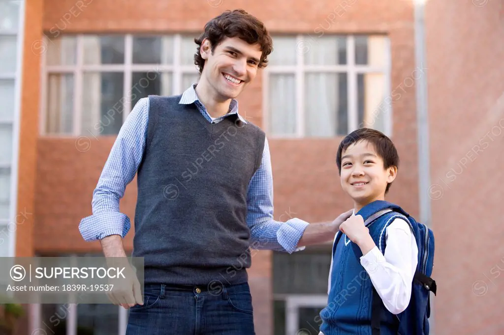Teacher standing with a student on campus