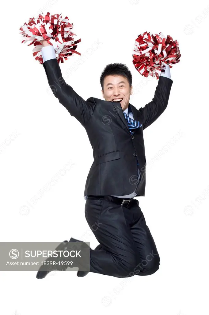 A businessman cheering with pompoms