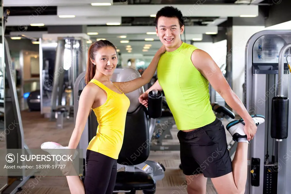 Young Couple Stretching at Gym