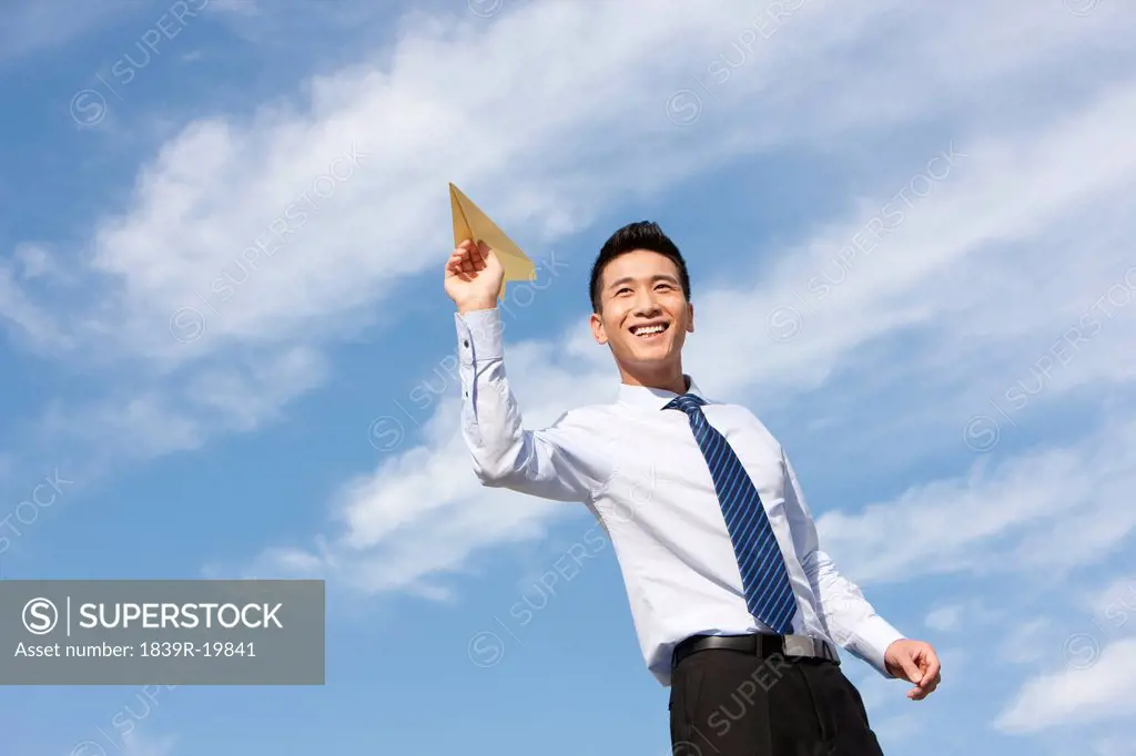 Businessman Throwing a Paper Airplane