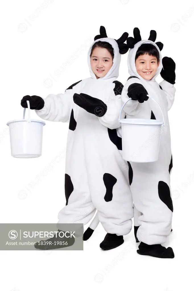 Children in cow costumes playing with buckets