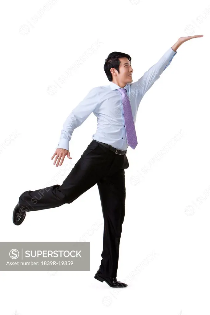 Businessman Reaching Up and Holding an Object