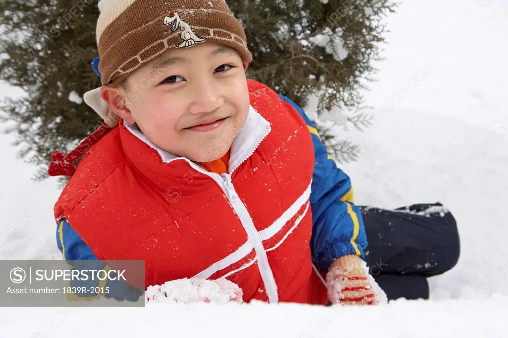 Boy Sitting In Snow On Ski Field