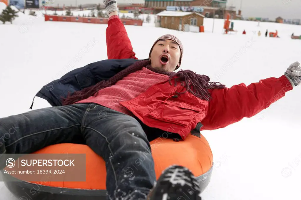 Man Riding On Inflatable Snow Tube