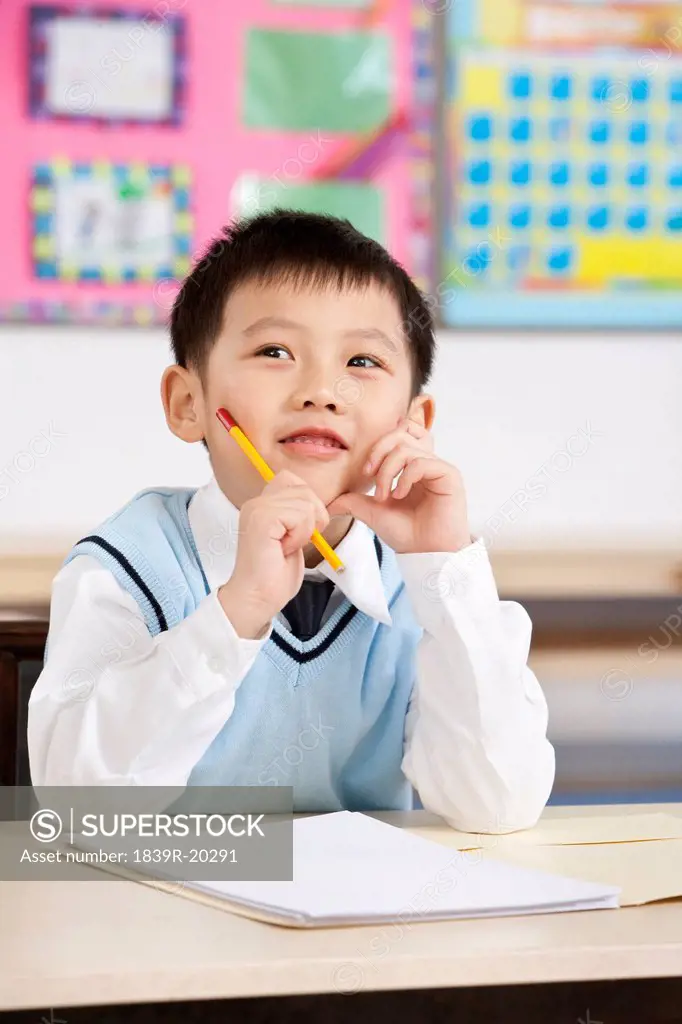 Young boy thinking about his work in class