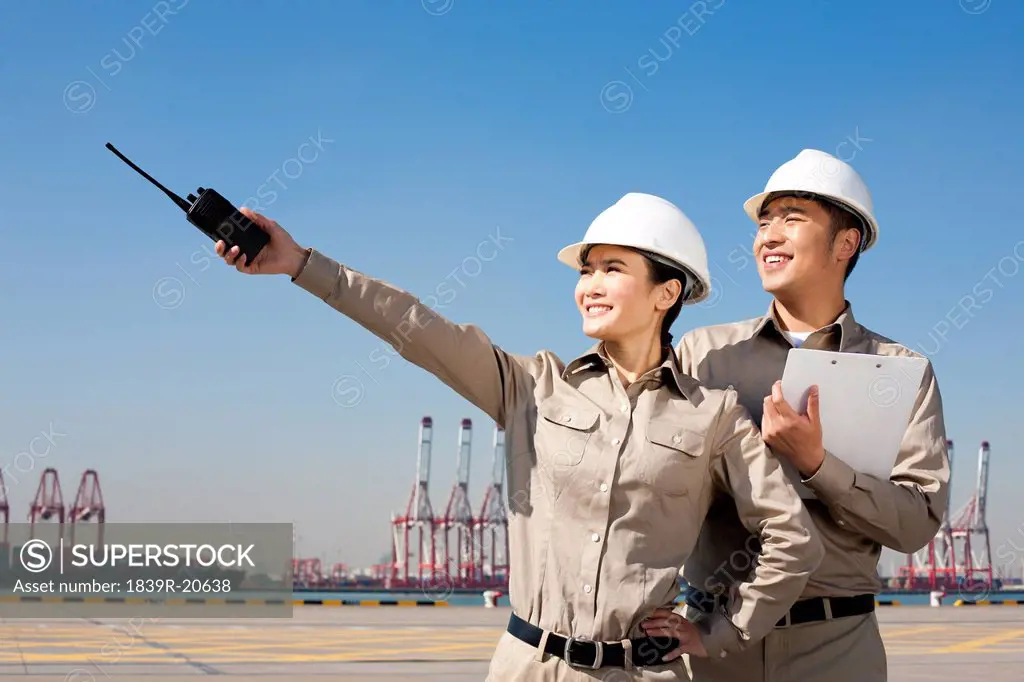 shipping industry workers pointing with walkie_talkie