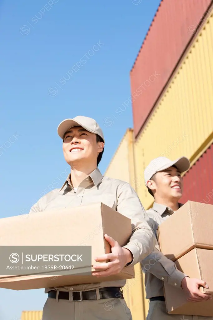 shipping industry workers carrying cardboard boxes