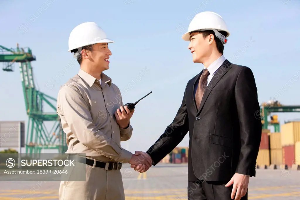 businessman and shipping industry worker shaking hands