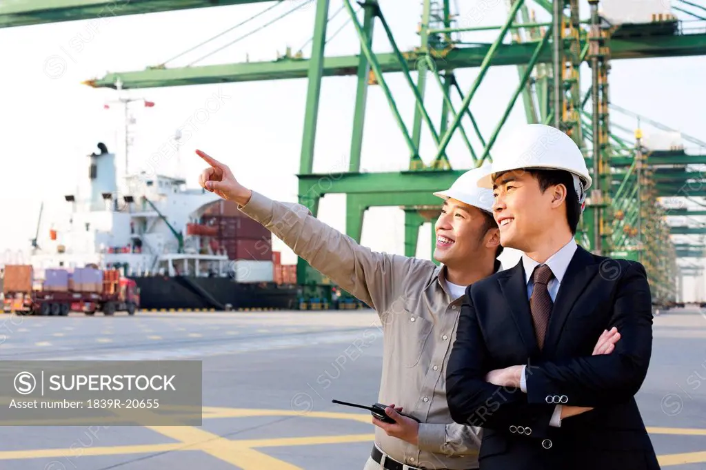 shipping industry worker showing a businessman around the port