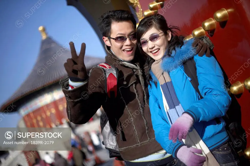 Couple Standing In The Temple of Heaven, Beijing, China, Man Doing Peace Sign