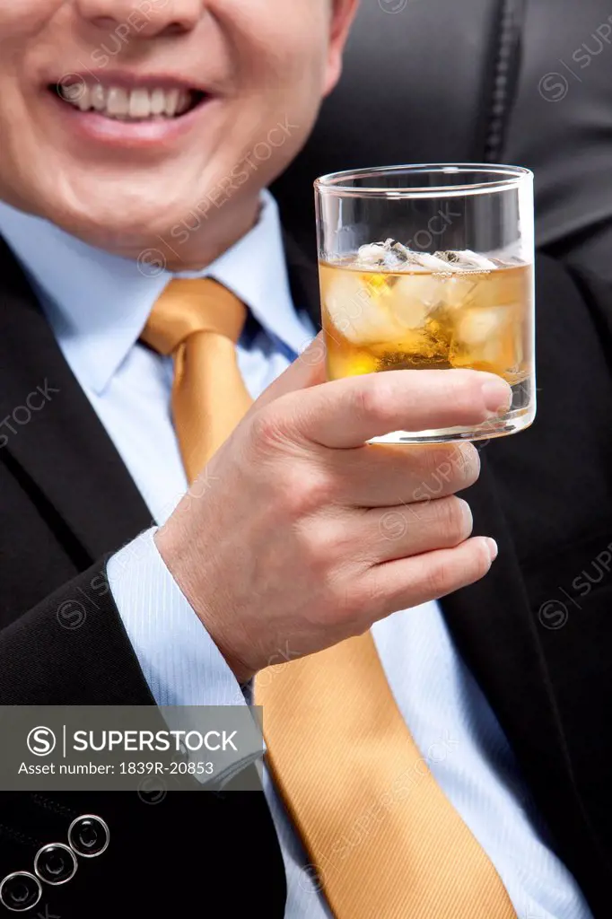 Businessman holding a glass of whiskey