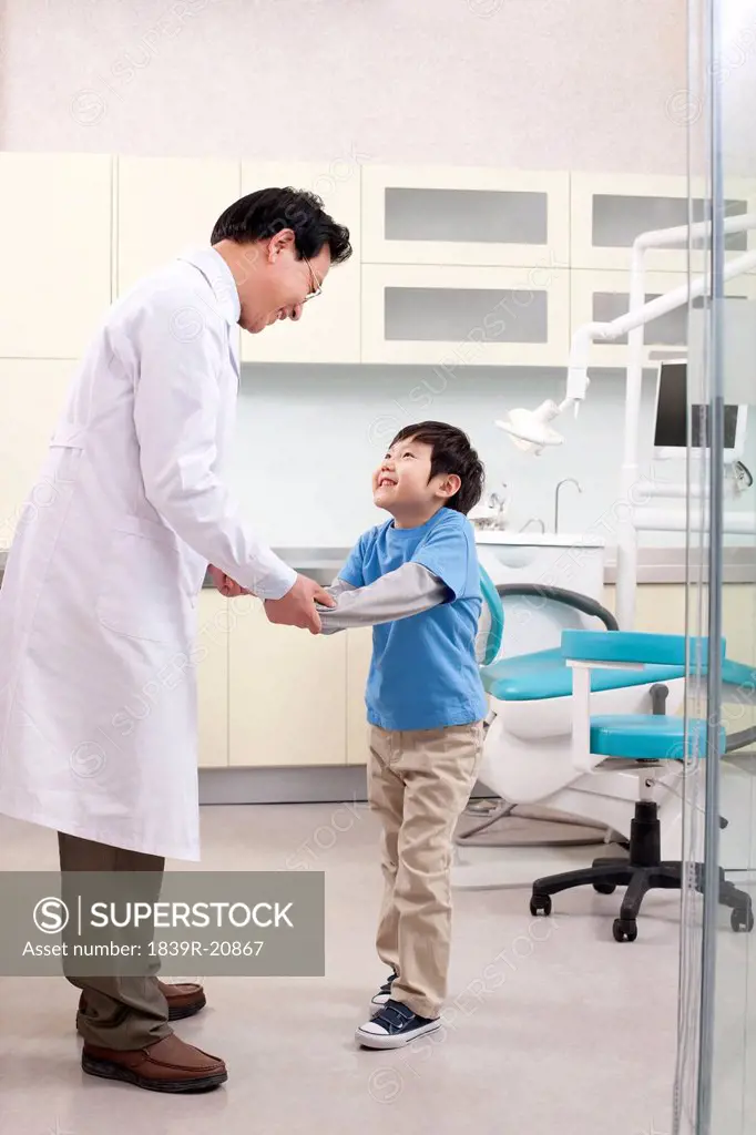 Dentist shaking hands with a little patient
