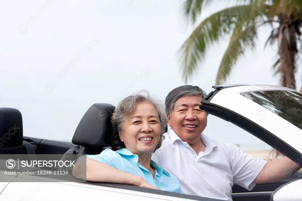Happy Senior Couple Posing in a Convertible