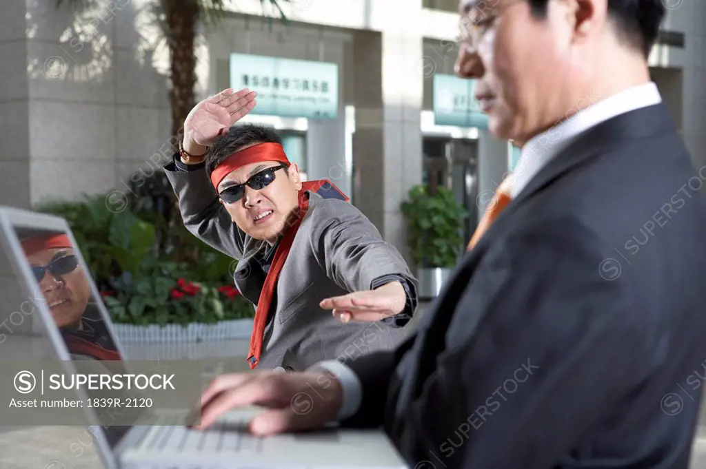 Businessman In Headband And Sunglasses Doing Karate Moves