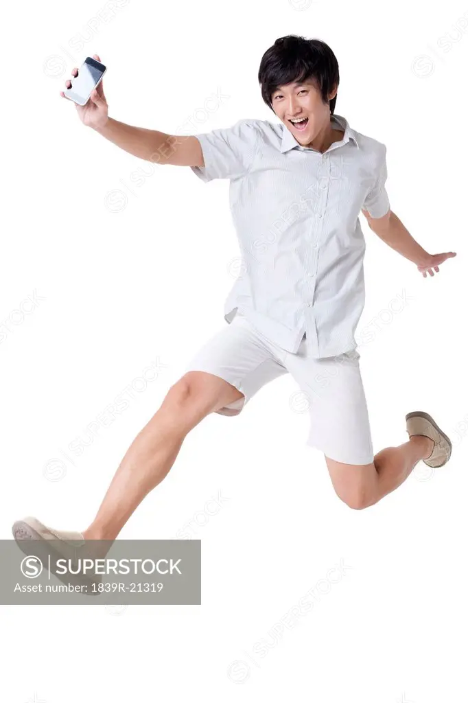 Young Man Jumping With a Mobile Phone