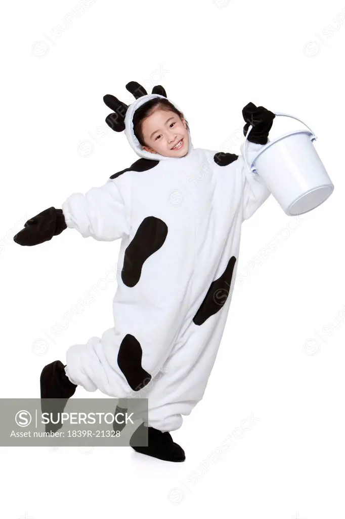 Cute girl in a cow costume with a bucket