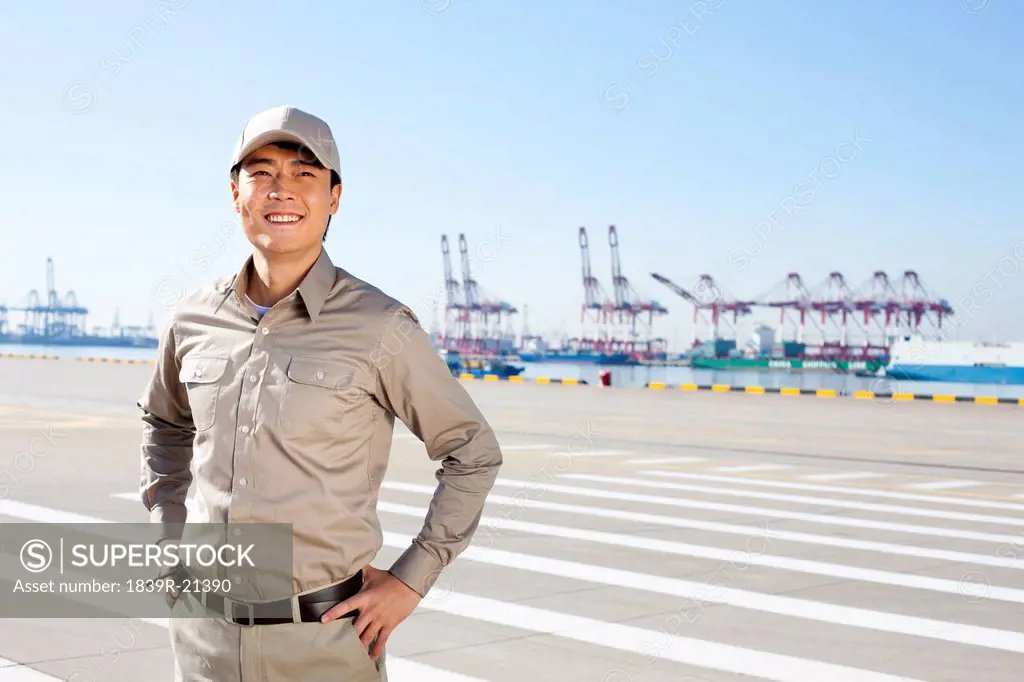 Male shipping industry worker with shipping dock background