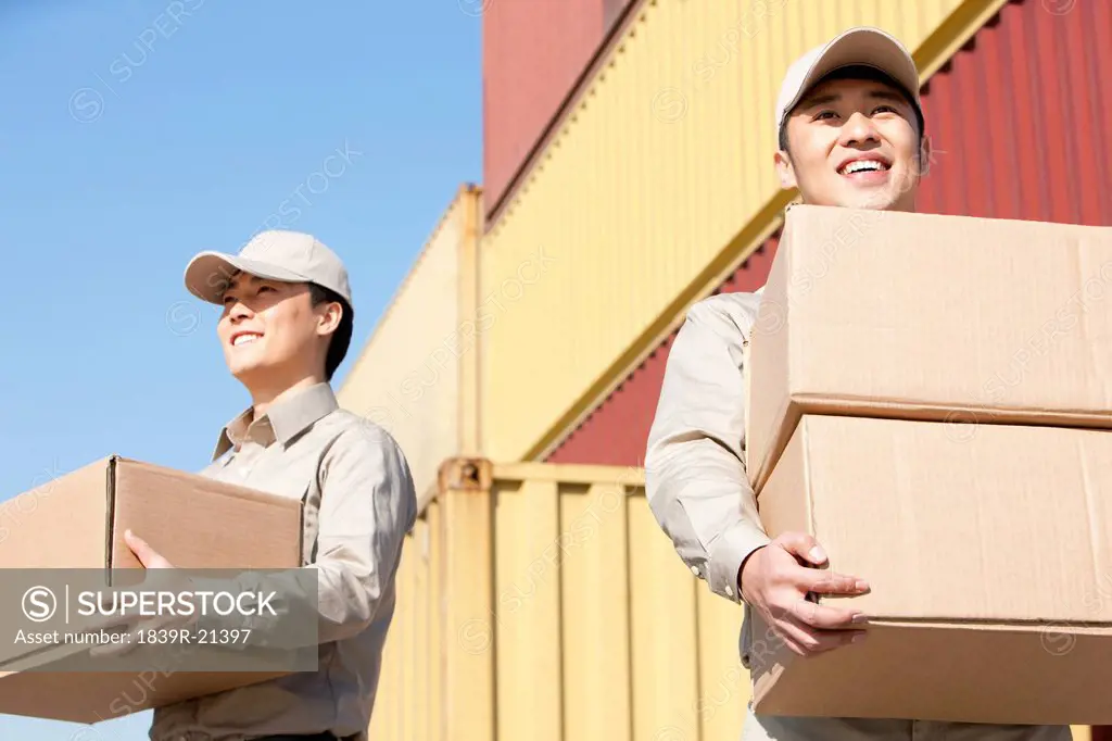 shipping industry workers carrying cardboard boxes