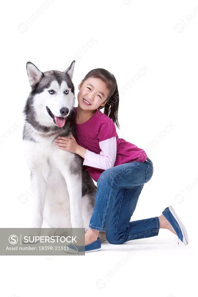 Cute little girl playing with a Husky dog