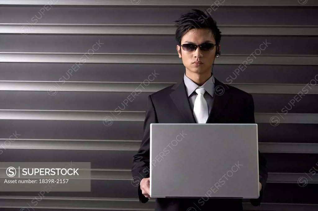 Serious Businessman Holding Laptop