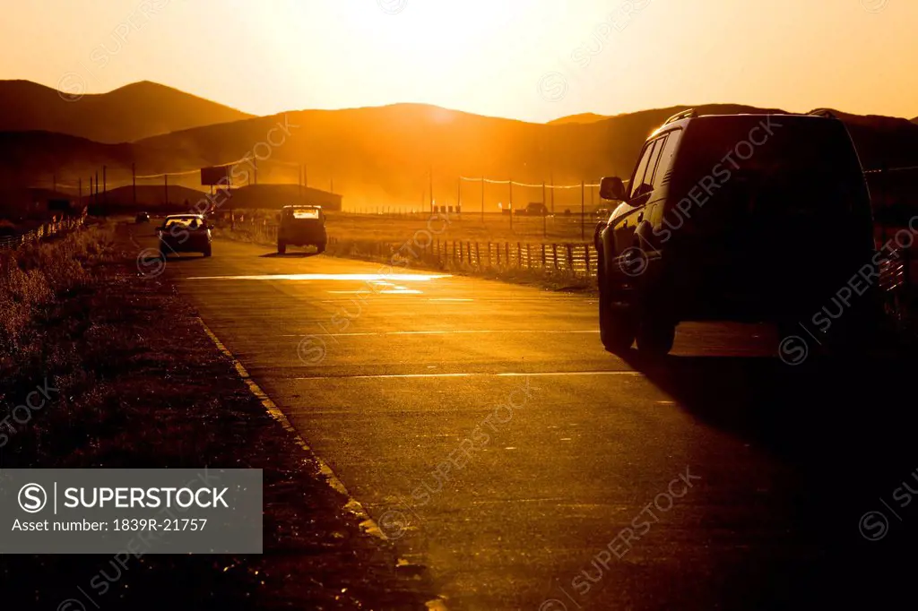 Cars on a country road at dusk