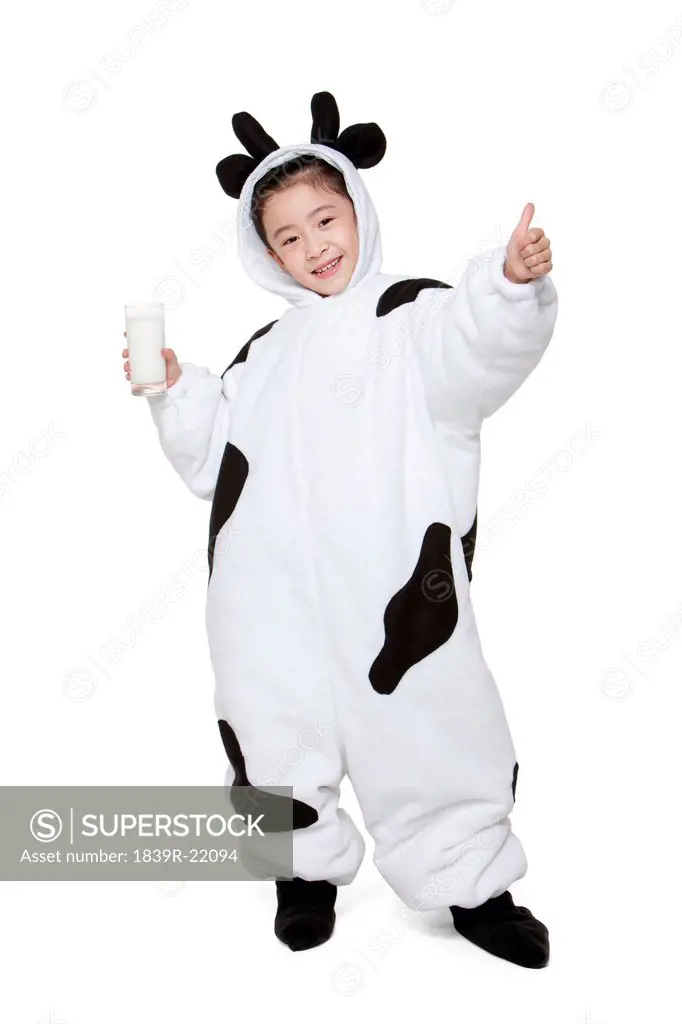 Cute girl in a cow costume with a glass of milk giving the thumbs_up sign
