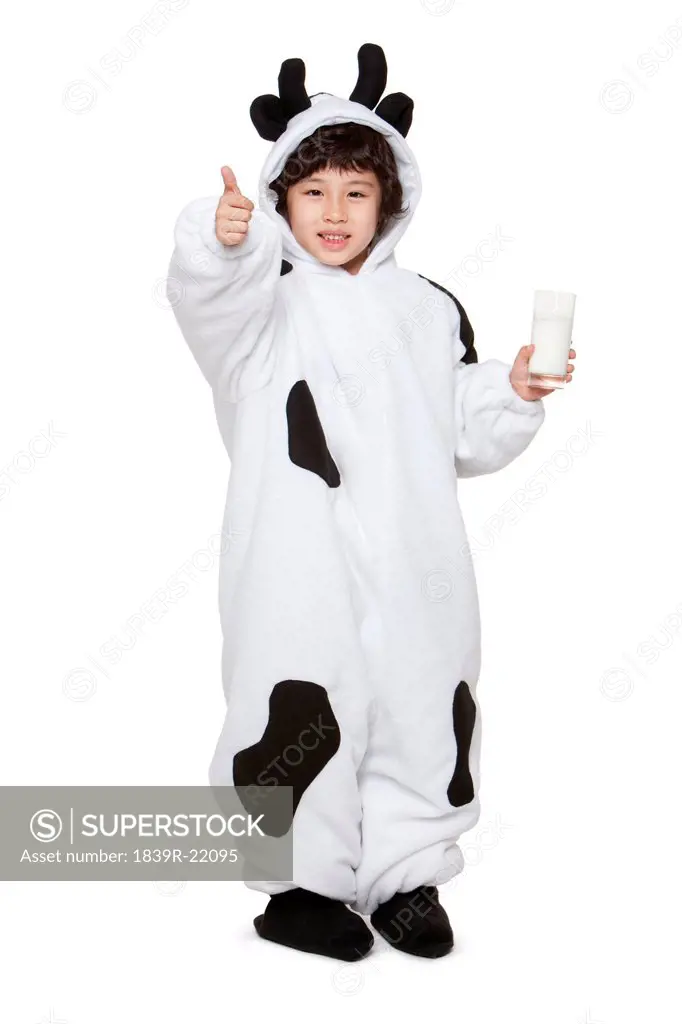 Cute boy in a cow costume with a glass of milk giving a thumbs_up sign