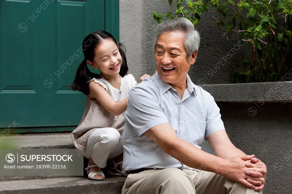 Chinese Grandfather and Grandaughter on front stoop