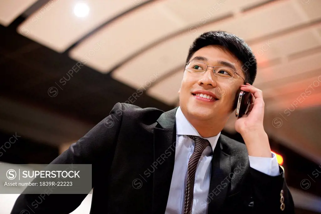 Young businessman using his mobile phone at the train station