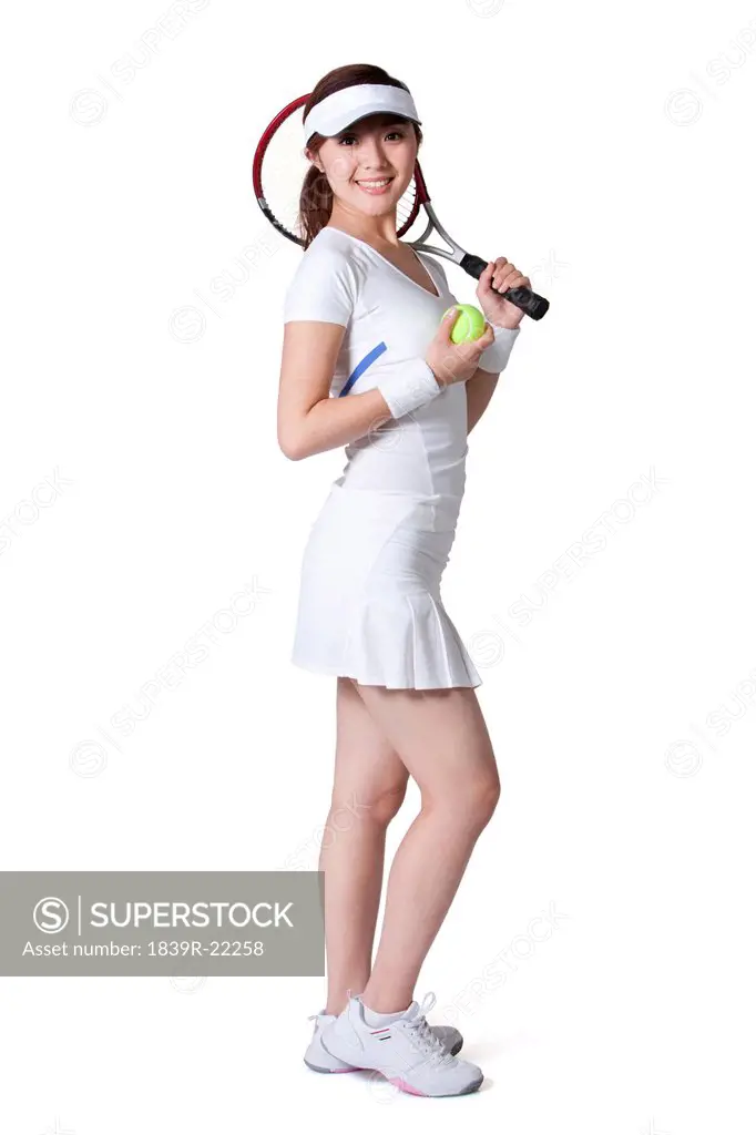 Young woman posing with tennis ball and racket