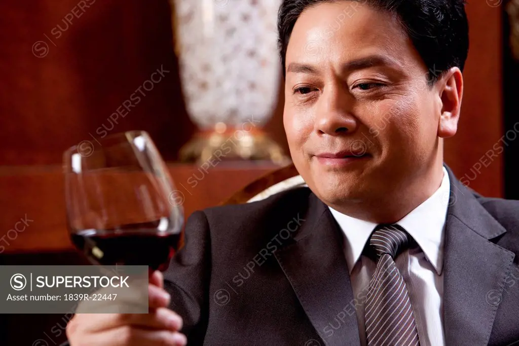 Mature businessman enjoying wine in a luxurious room