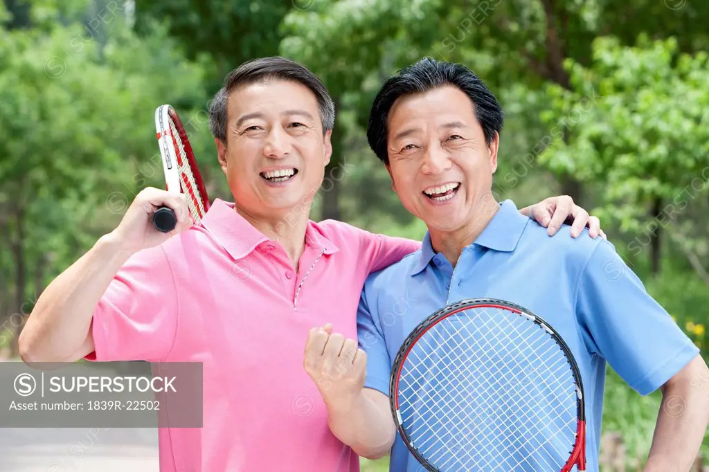Senior friends playing tennis in park