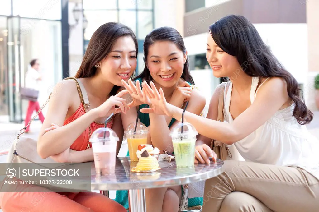 Best female friends sitting at sidewalk café