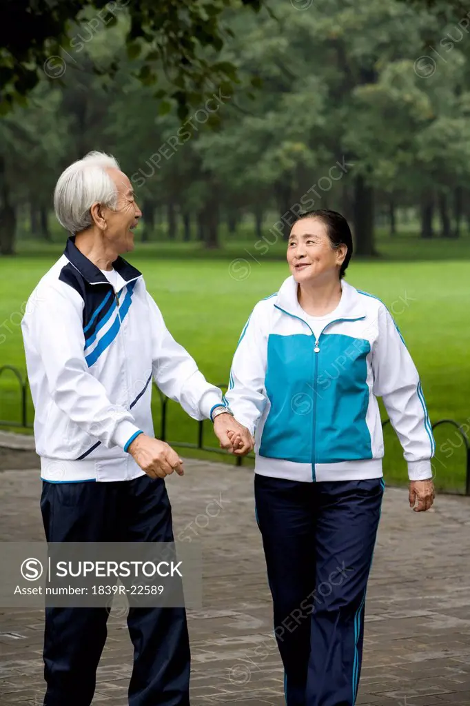 Senior Couple Walking Hand_In_Hand Through a Park