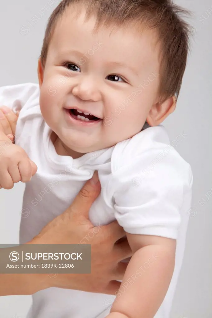 Studio shot of a cute baby boy being picked up