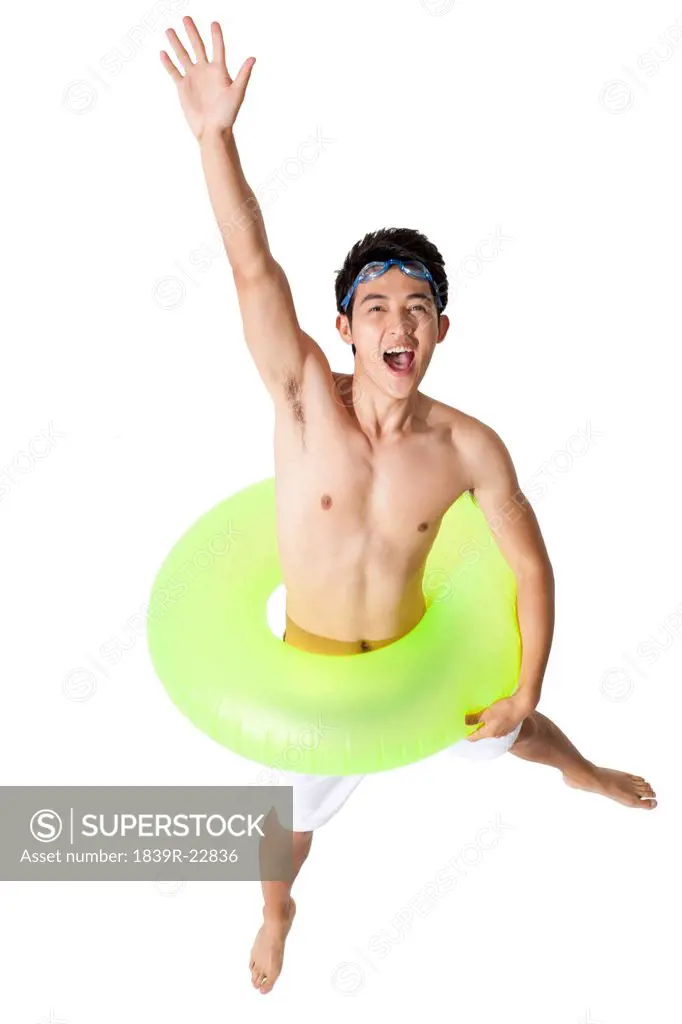 Young man in swimsuit with swim ring