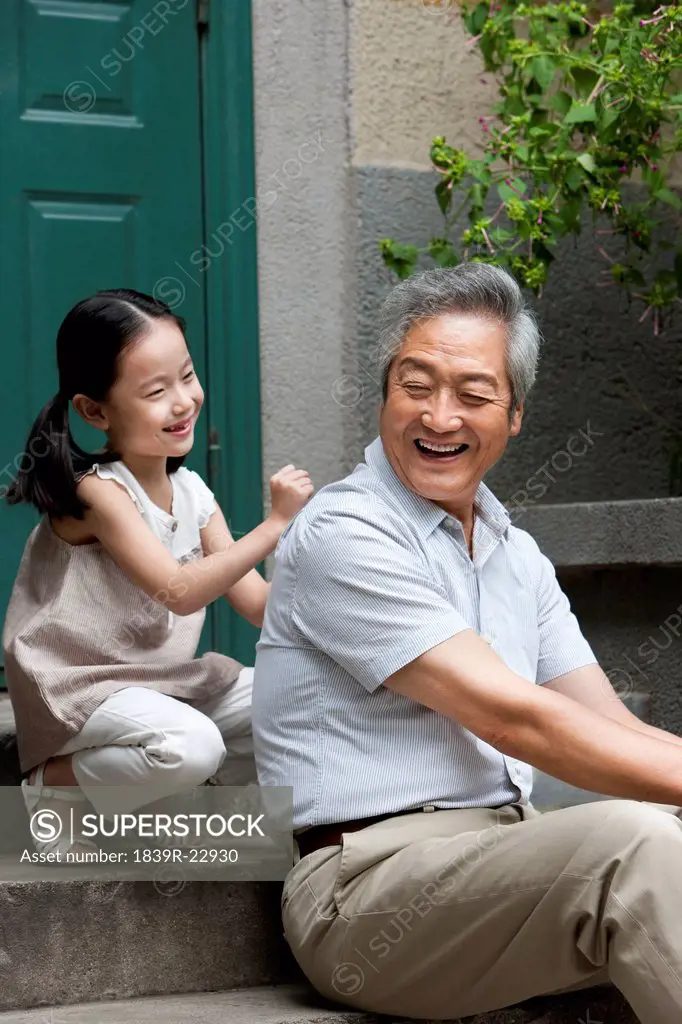 Chinese Grandfather and Grandaughter on front stoop