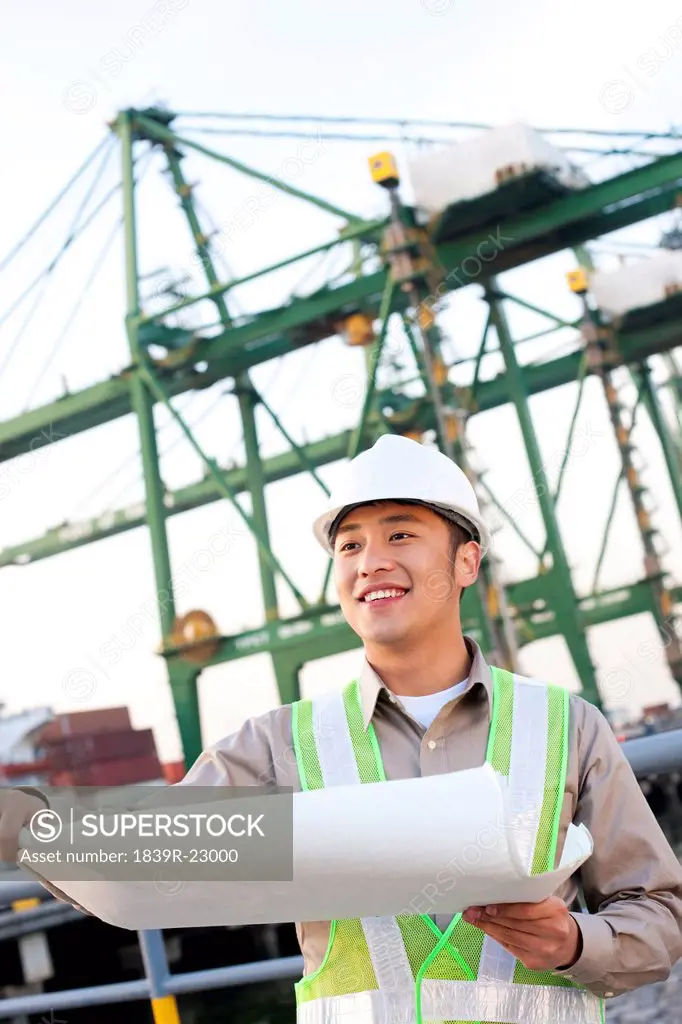 shipping industry worker looking over blueprints