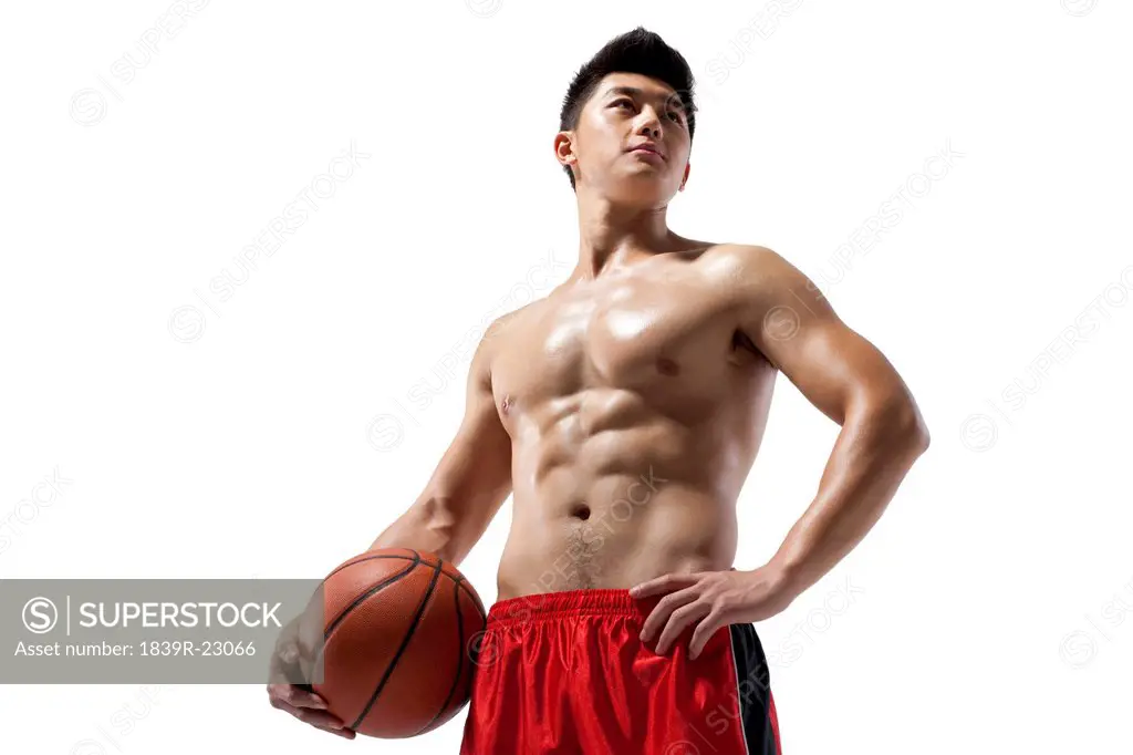 Shirtless muscular man holding a basketball
